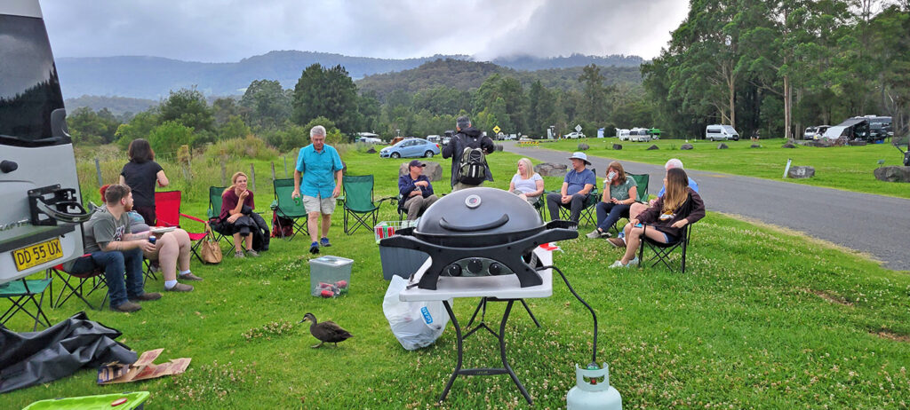 People seated in a semi-circle for a cookout at Bendeela Recreation Area, NSW