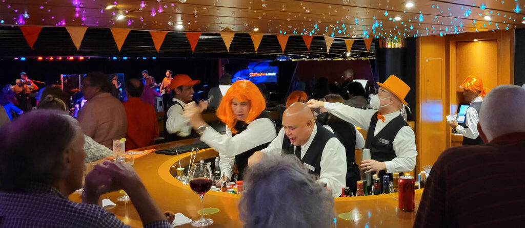 Bartender wearing an orange wig at the Orange Party aboard Holland America's Noordam