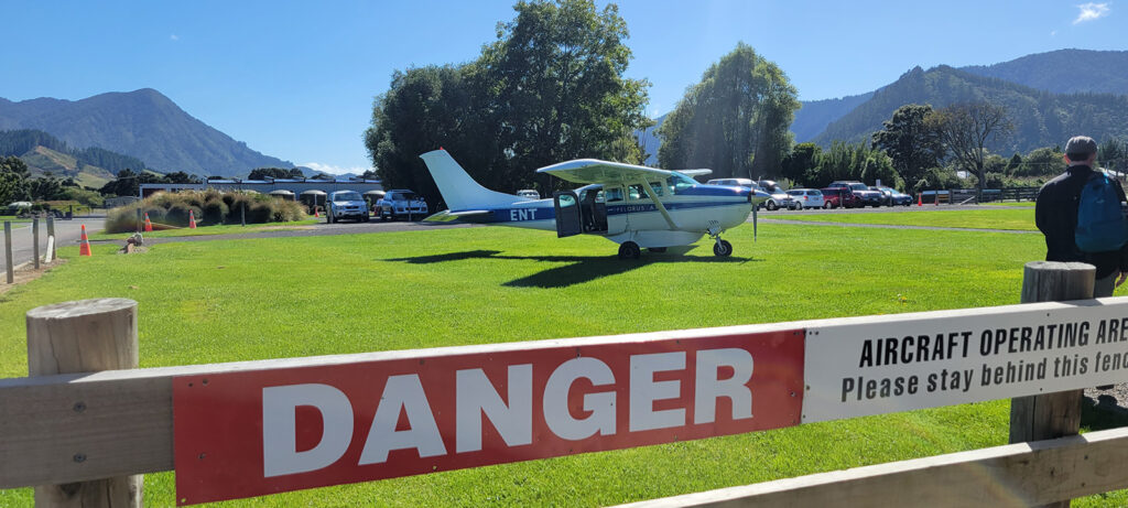 Small single engine plane sitting on grass at the Picton, NZ airport