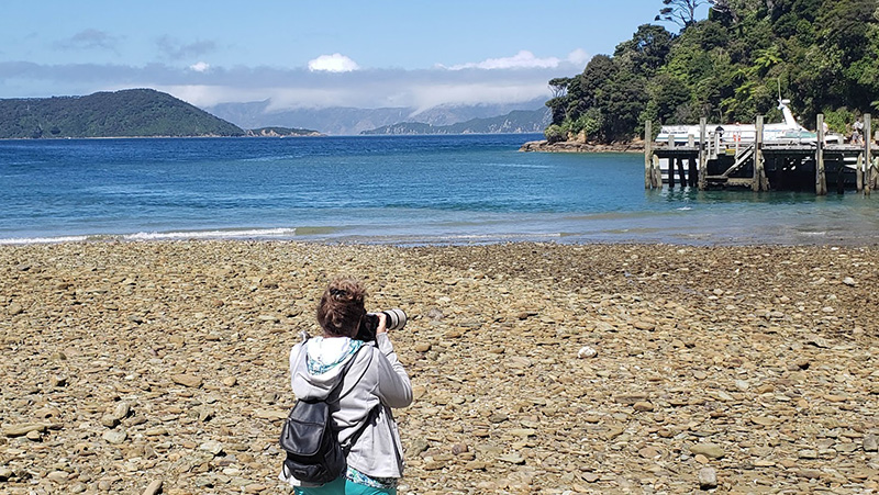 Cathy taking photos at Chip Cove in Queen Charlotte Sound, NZ