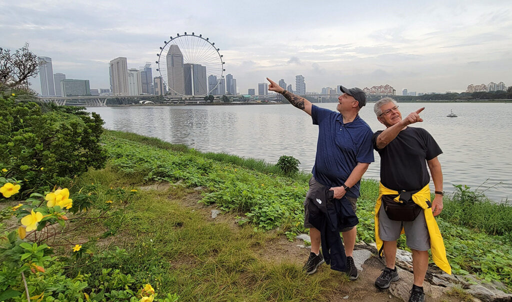Two men pointing in different directions along the river in Marina Bay, Singapore