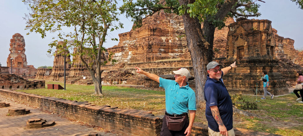 Two men pointing in different directions at an archeological site in Ayutthaya, Thailand