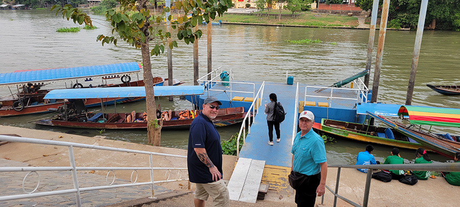 Two men standing at the top of a ramp down to canal boats