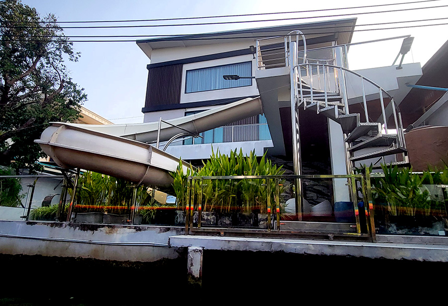 A modern home with a slide along a canal in Bangkok, Thailand.