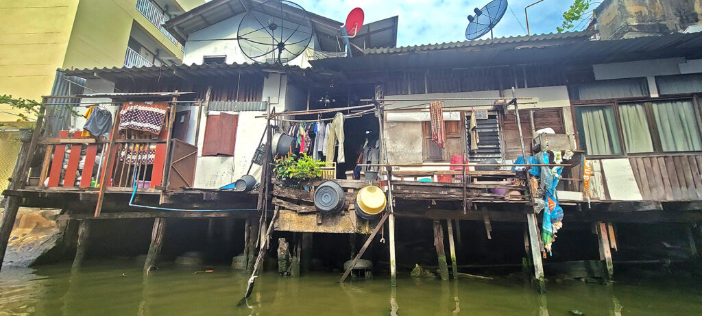 Very poor homes along a canal in Bangkok.