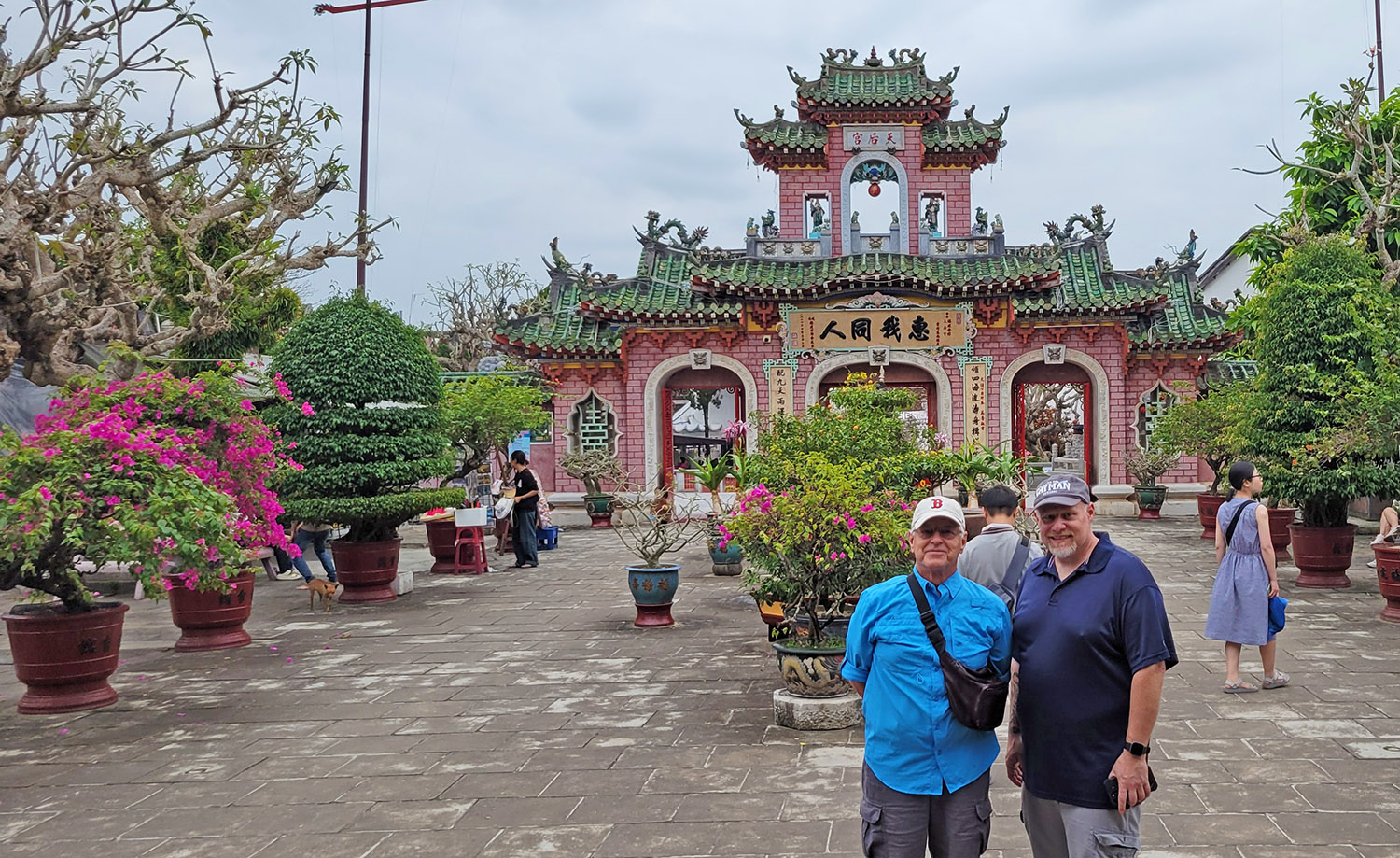 Two men standing in front of the gate to the Fujian Assembly Hall in Hoi An, Vietnam