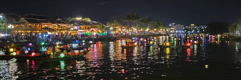 Hoi An, Vietnam waterway at night lit up with lanterns and filled with small boats.
