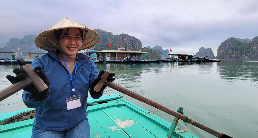 Vietnamese woman holding the oars in a row boat in Ha Long Bay Vietnam