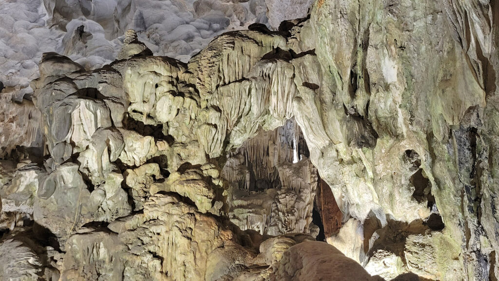 Inside the Heavenly Palace Cave in Ha Long Bay, Vietnam. There is an opening in the rock that serves as a window to look into the next room of the cave.