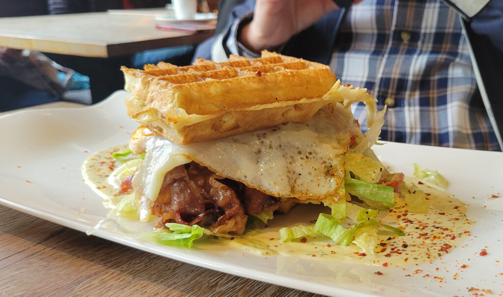 A sandwhich with waffles instead of bread, filled with a fried egg, bacon and lettuce.