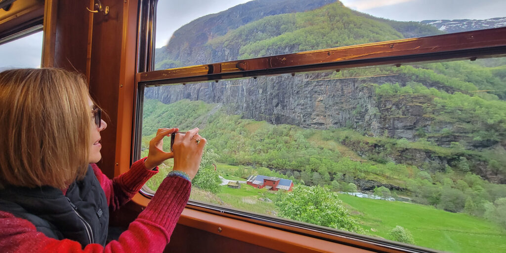 Women taking a photo from the window of the scenic railway in Flåm
