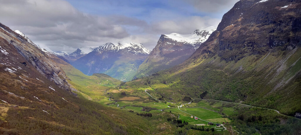A beautiful green valley in Norway surrounded by snow-capped mountains