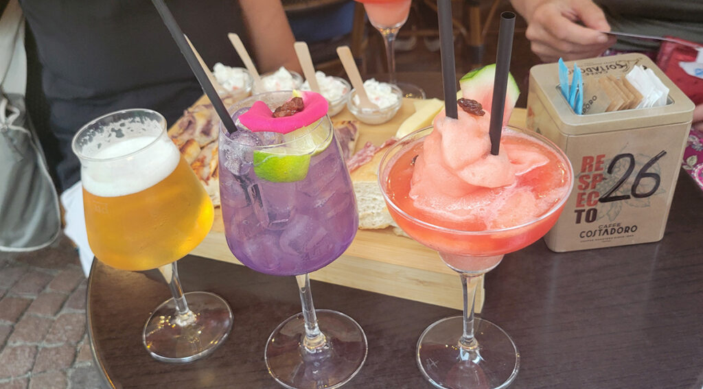 a beer and two colorful cocktails