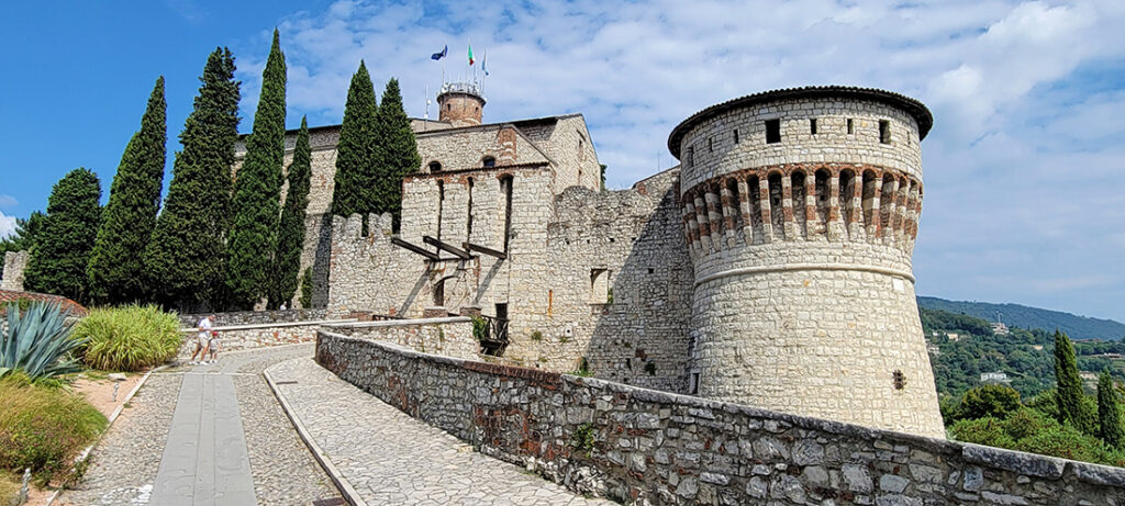 A medieval castle with a walkway leading up to the gate.
