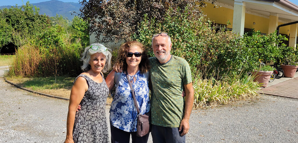 3 people standing in a driveway with garages behind them
