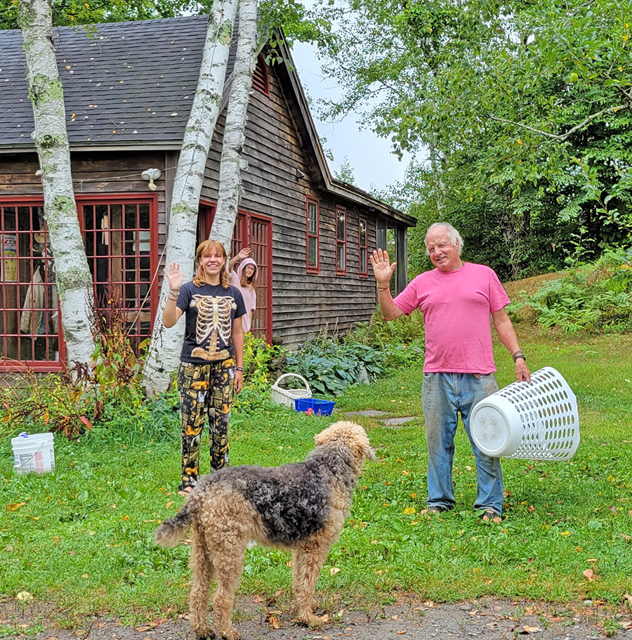 A man, a young woman, and a teenage girl waving goodbye