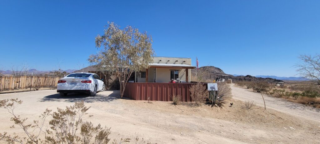 A small casita with a white car parked outside of it